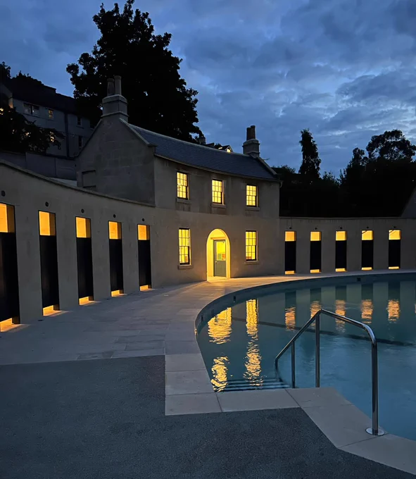 Crescent of Cleveland Pools at dusk with the caretakers cottage and changing rooms illuminated.