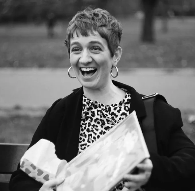 Black and white photo of ecstatic woman with hoop earrings and a leopard print top