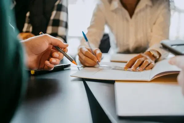 Hands holding a writing instrument with one writing on paper