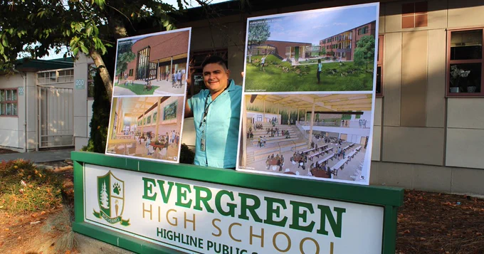 Principal with new school designs and current school sign