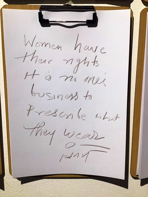 A wooden clip board with black handwriting on