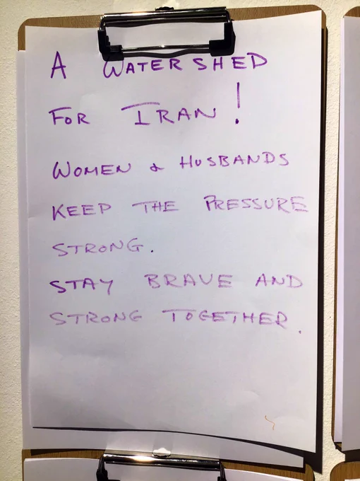 A wooden clip board with purple hand writing on