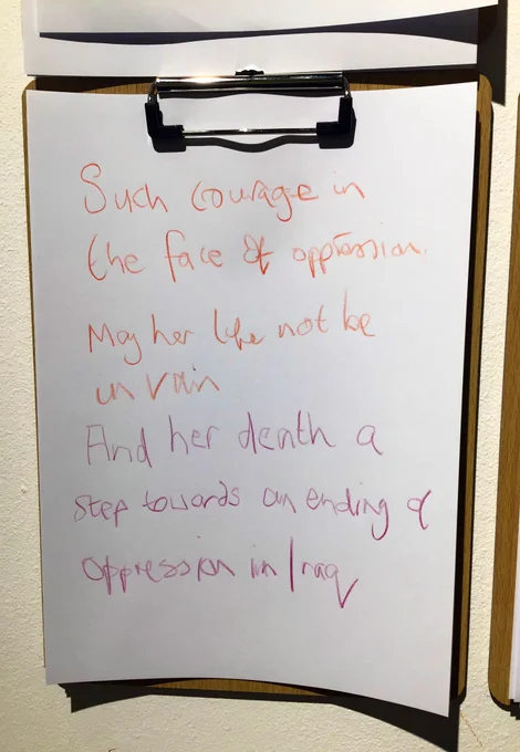 A wooden clip board with purple and orange handwriting on