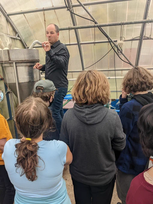 Mr Roes explains the biofilter to students in the aquaponics lab in greenhouse.