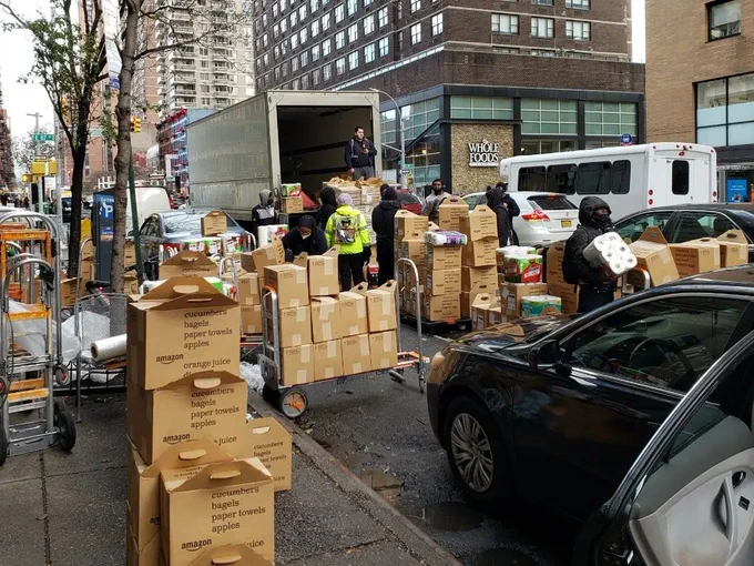 Packages piled up for delivery on a sidewalk and in the street.