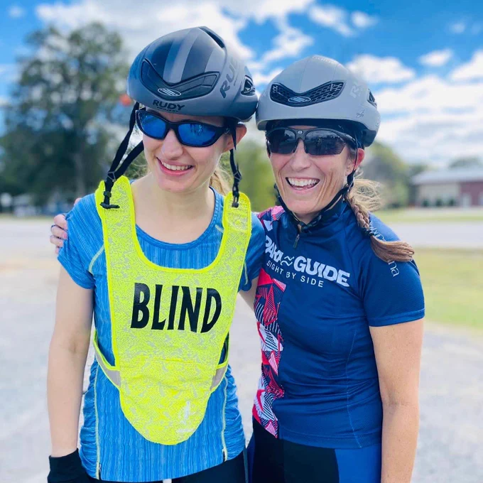 Alexandra and Shannon are laughing after their ride wearing cycling gear and helmets