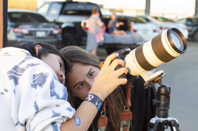 Two high school astronomers line up a moon shot on a Canon DSLR camera.