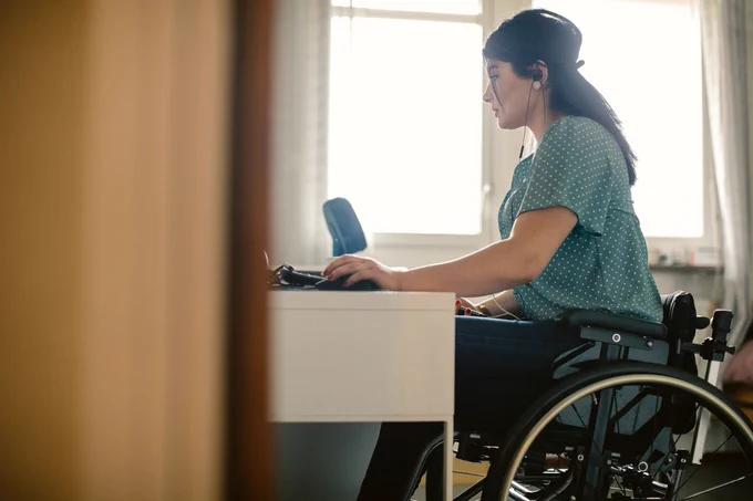 Woman in wheelchair works at computer.