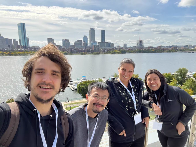 Four people standing in front of Boston skyline