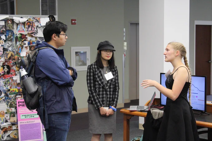 A W&M student sharing his research research project with peers.
