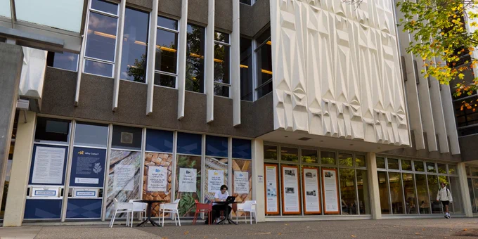 Wide shot of UVic McPherson Library showcasing window decals with  art designs and information on residential schools