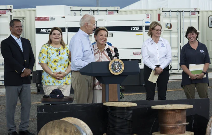 President Biden at a podium flanked by several people.