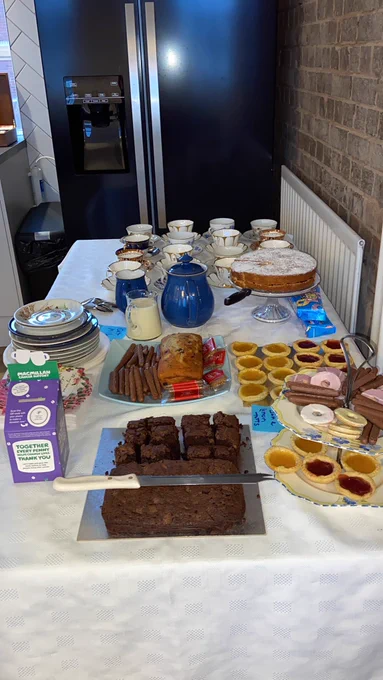 Table full of tea cups and cake