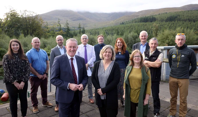 Minister Murphy stands with Antonia Boyce from the James Hutton Institute and a number of other Mournes stakeholders, with a backdrop of the Mourne Mountains.