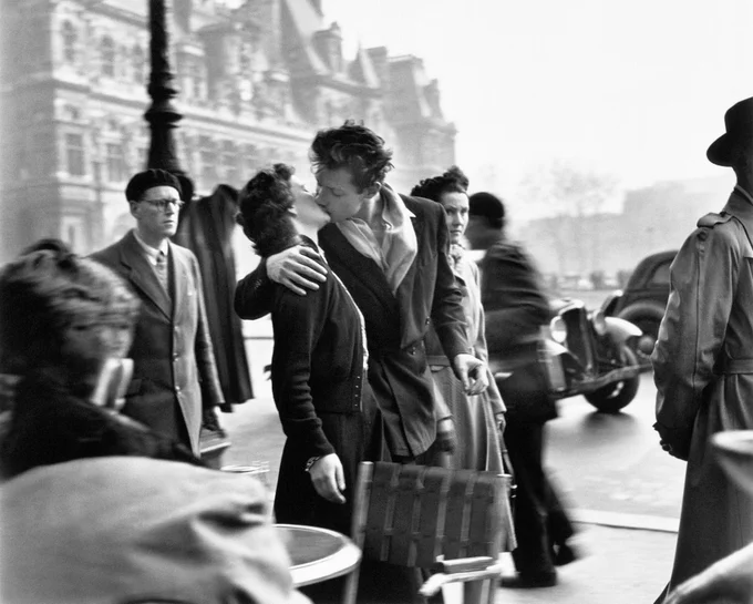 Il bacio di una giovane coppia indifferente alla folla dei passanti e al traffico della place de l’Hôtel de Ville di Parigi negli anni '50. Lo scatto di Robert Doisneau è uno dei baci più celebri nella storia della fotografia