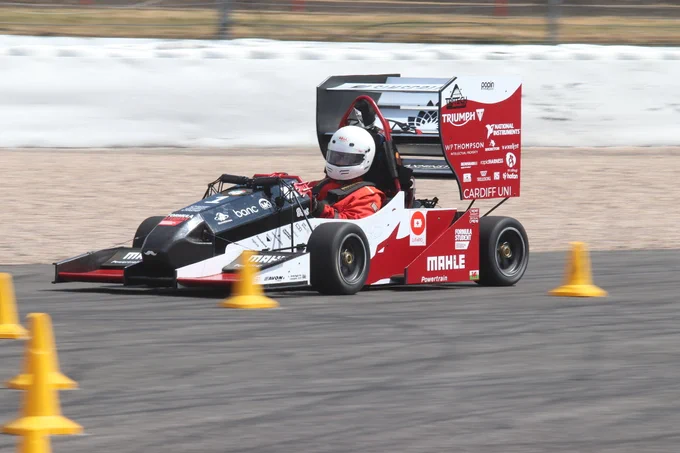 Cardiff University's black, white and red car prepares to take a corner on the sunny Sprint Course during Formula Student 2018 on Copse Corner at Silverstone.