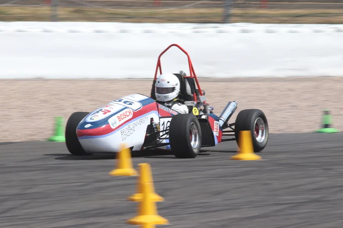 Brunel University's white, blue and red striped car prepares to take a corner on the sunny Sprint Course during Formula Student 2018 on Copse Corner at Silverstone.
