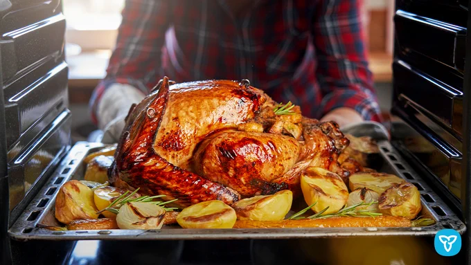 Person taking the turkey out of the oven.