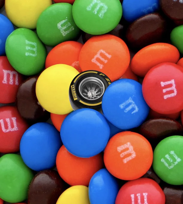 A pile of M&M's with a medium black-and-yellow Pirelli F1 tire photoshopped into it.