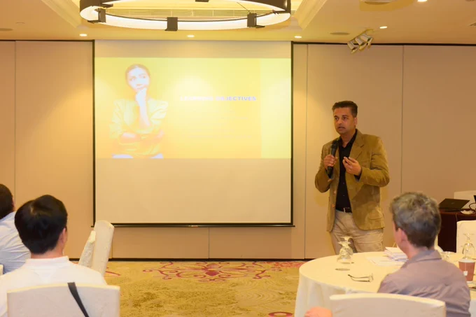 Man speaking into a microphone in a conference room