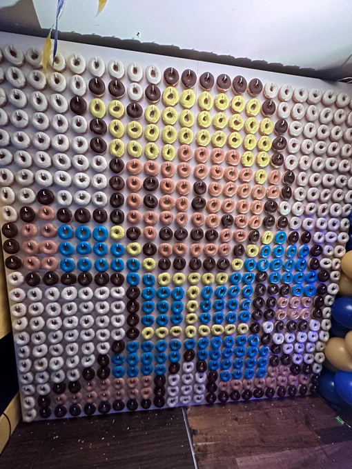 A pixel image on a wall of a Vault Boy from Fallout. But what is it made of? The next image reveals the close up.
