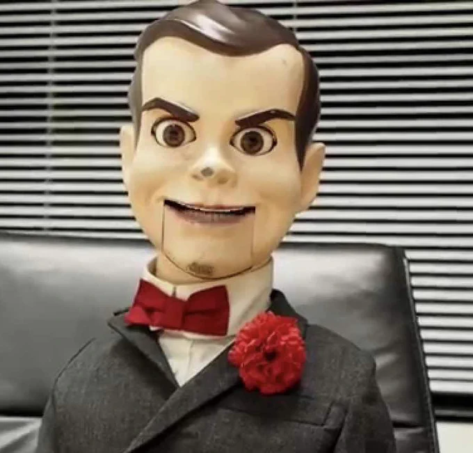 Slappy the evil puppet from the Goosebumps series, in a black suit with a red tie