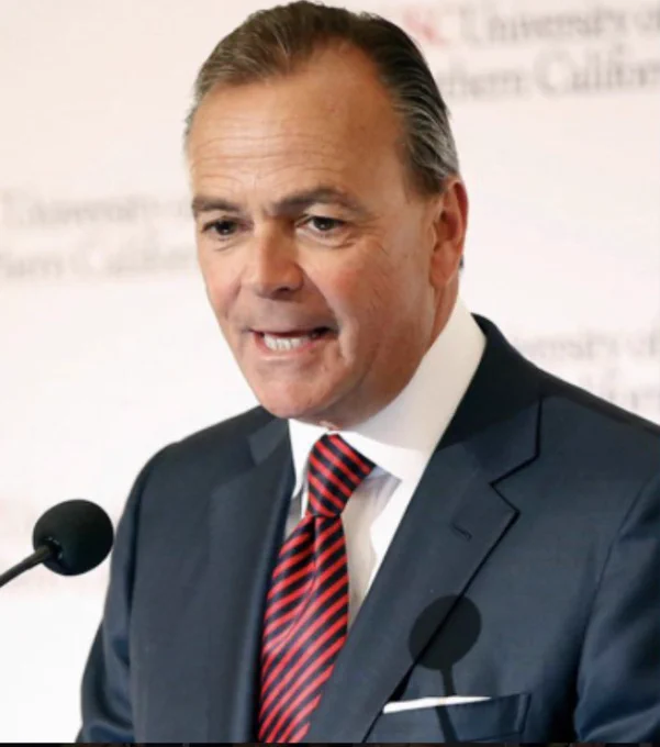 Rick Caruso in a black suit with a red tie