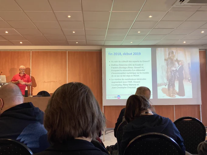 Photo de la vue d’une spectatrice de la conférence de Christophe présentant une diapositive rappelant l’historique avec une photo de Chewbacca se faisant recoiffer.