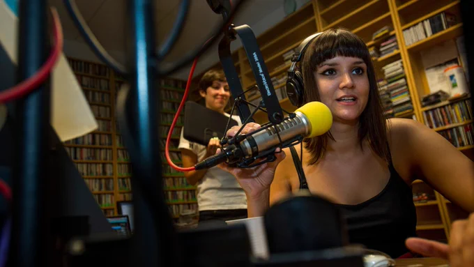 A WTUL DJ speaks into a yellow microphone while on air.