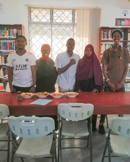 Hatua Library team standing behind a table with snacks.