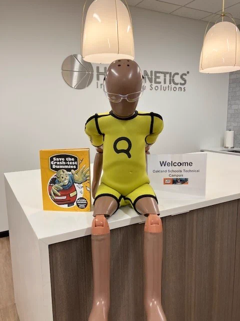 Mfg Day students are welcomed to Humanetics by a crash test dummy wearing safety goggles.