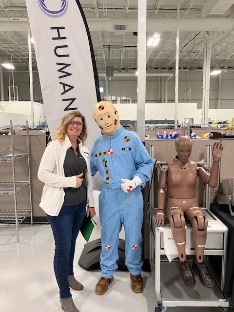 Humanetics staff poses with crash test dummy Vince.