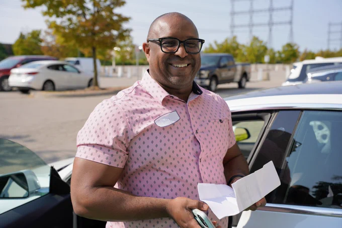 Jerry standing in front of his Tesla