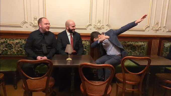 Sean and Feras looking at Max in a suit dabbing