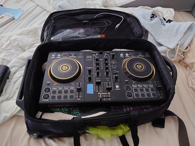 A Pioneer DJ model DDJ-400 DJ controller barely fitting in a suitcase.