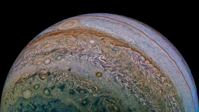 A view of Jupiter taken by the Juno spacecraft. The planet is enveloped in swirling clouds and storm systems and the Great Red Spot is visible in the upper left. The planet showcases hues of orange, white, and blue. 

Image credit: NASA / JPL / SwRI / MSSS / David Marriott