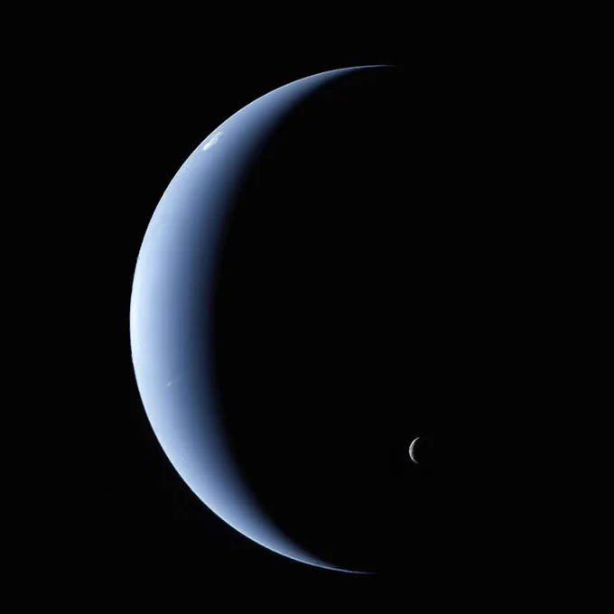 A view of Neptune and its moon Triton from Voyager 2. Neptune appears as a blue crescent shape and Triton is a much smaller gray crescent shape. 

Image Credit: NASA/JPL-Caltech/Kevin M. Gill