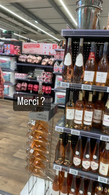 Photo d'un rayon de supermarché entièrement rempli de produits roses : du vin rosé, des crocs rose, des vêtements roses, des gel douches et shampoing rose...