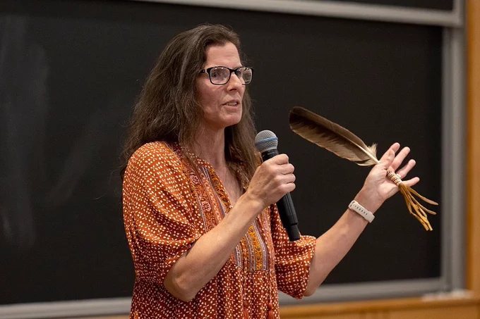 Esther Anne of the Passamaquoddy tribe gives a speech while holding a feather in her left hand.