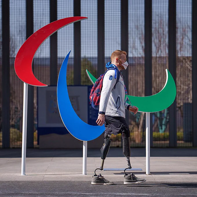 Para Ice Hockey player Declan Farmer walks by the Agitos logo, in the Paralympic Village at the Beijing 2022 Paralympic Games.