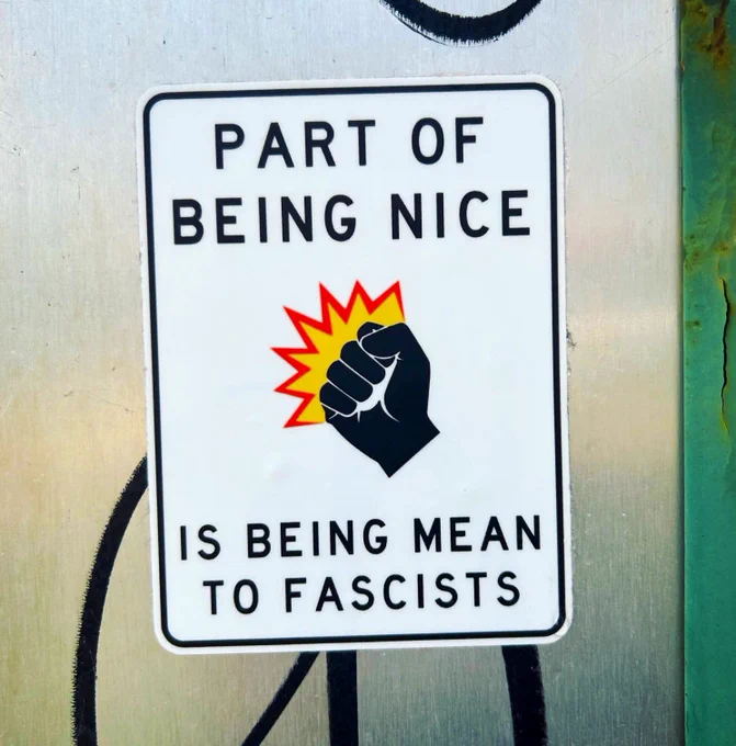 sticker von @cnspeckhardt an der rückseite eines metallschilds: auf dem weißen sticker ist eine symbolisierte schwarze faust die zuschlägt abgebildet, dazu steht in schwarzen großbuchstaben: PART OF BEING NICE IS BEING MEAN TO FASCISTS.

der sticker wirkt selbst wie ein hinweisschild.