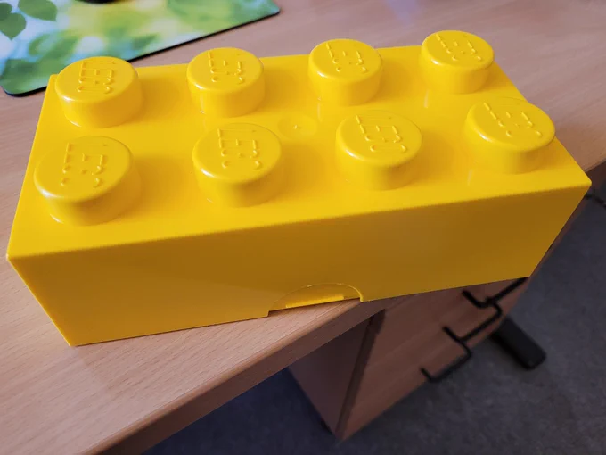 Ein Bild meiner gelben Lego Brotdose, die die Form eines Legosteins hat.