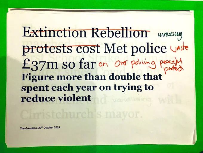 A redacted newspaper headline with red and green felt tip words crossed out and added