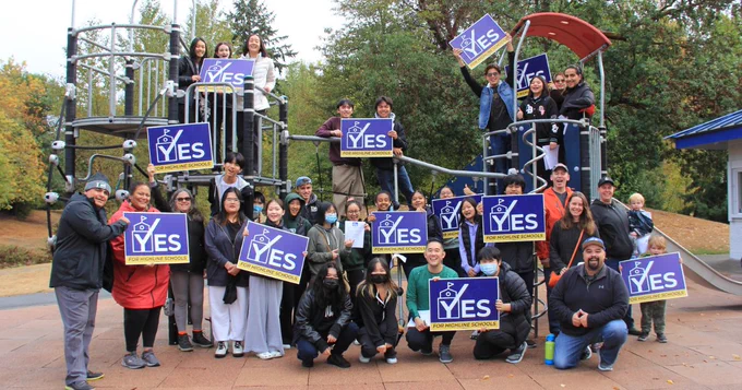 Photo of a large group of students and supporters holding Yes for Highline Schools signs.