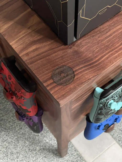 A top down shot of the top of the cabinet, looking at four controllers with the design for Xbox logo embossed on the top of the cabinet