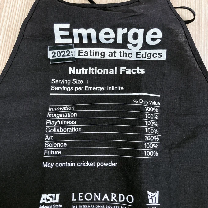 A black apron reading "Emerge 2022: Eating at the Edges," and formatted like a nutritional label on food or drink.