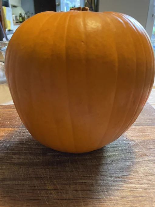 A pumpkin sitting on a chopping board