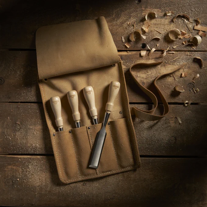 The 4 pc. SweetHeart™ 750 Series Socket Chisel Set resting in the tool roll on a wooden table. 