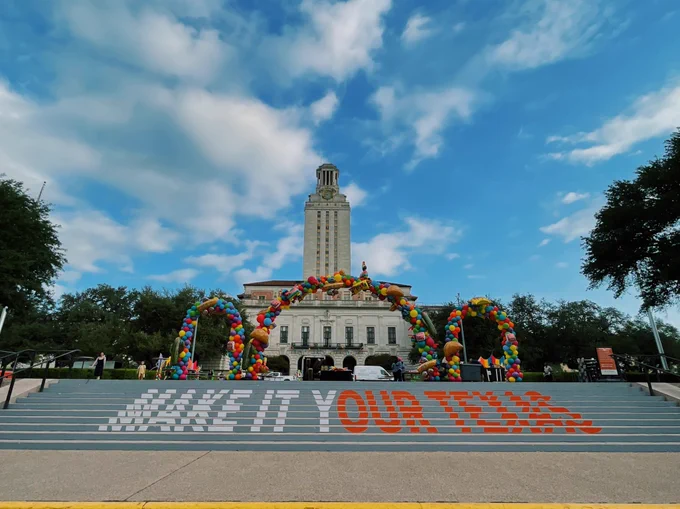 Pictured is a “Make It Your Texas” sign on the steps in front the Tower with Longhorn Fiesta decor.
