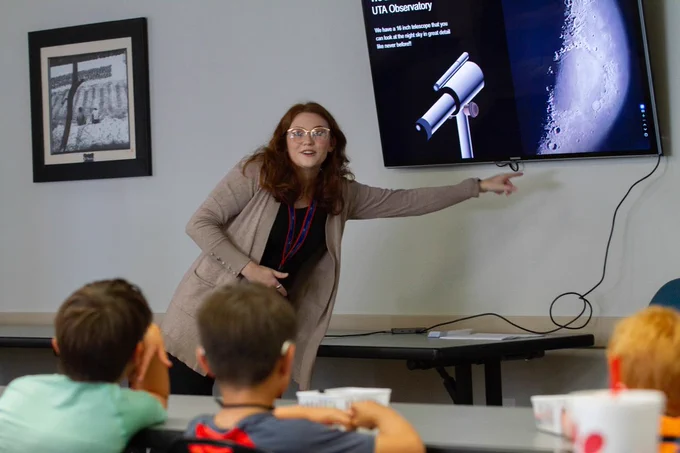 McKenna Dowd, UTA Planetarium Assistant, points to a photo of the moon taken with her phone from the UTA Observatory last week.